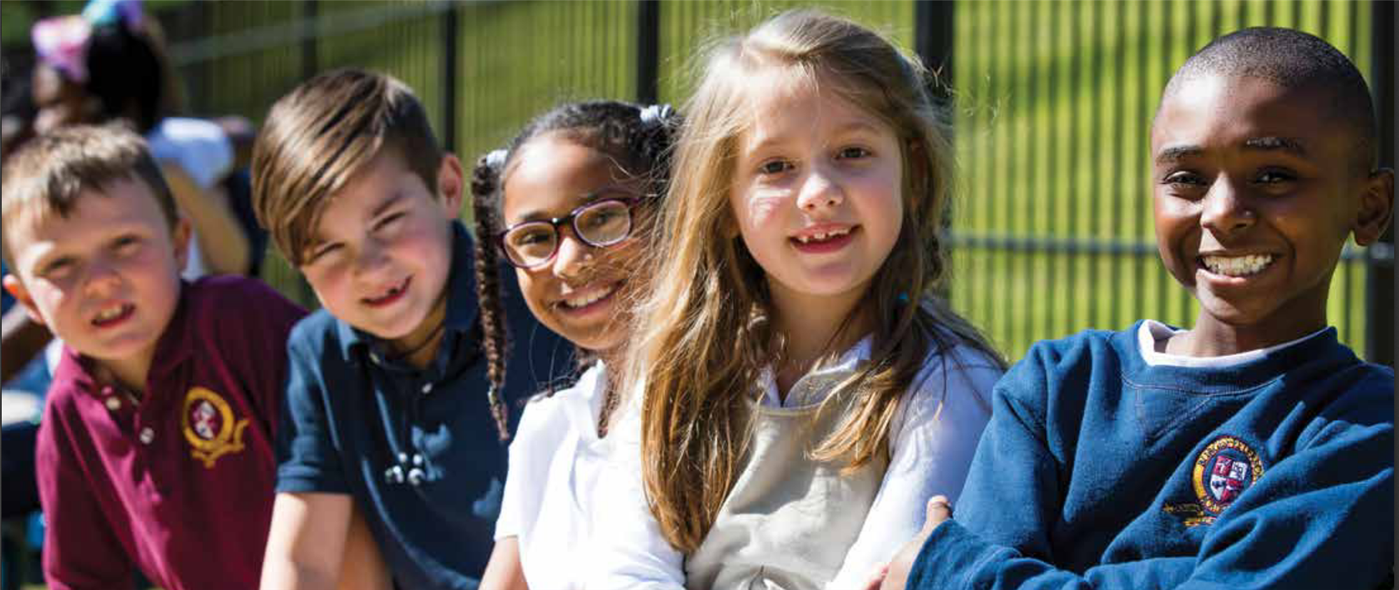 Burgess-Peterson Students smiling outside near iron gate. 